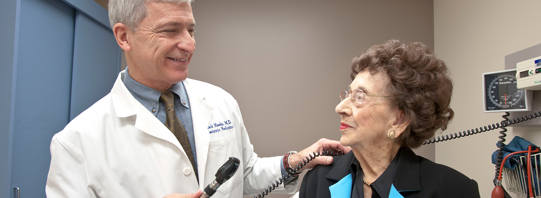 A doctor examining a geriatric patient with an otoscope.